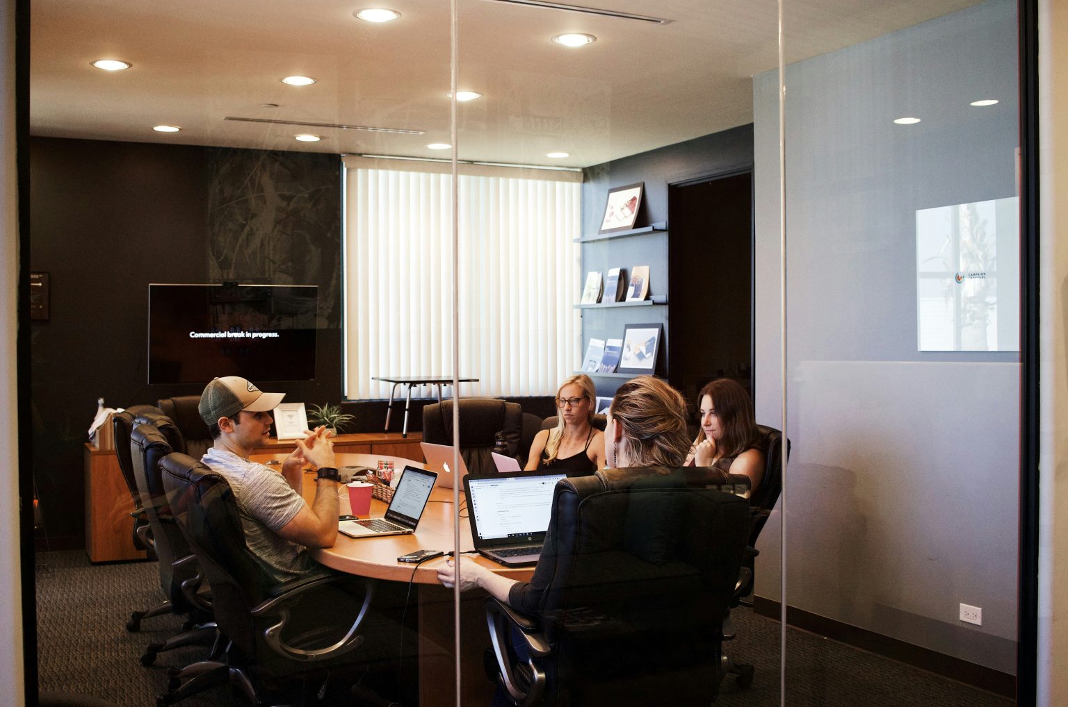 A group of business leaders collaborating around a table in front of laptops