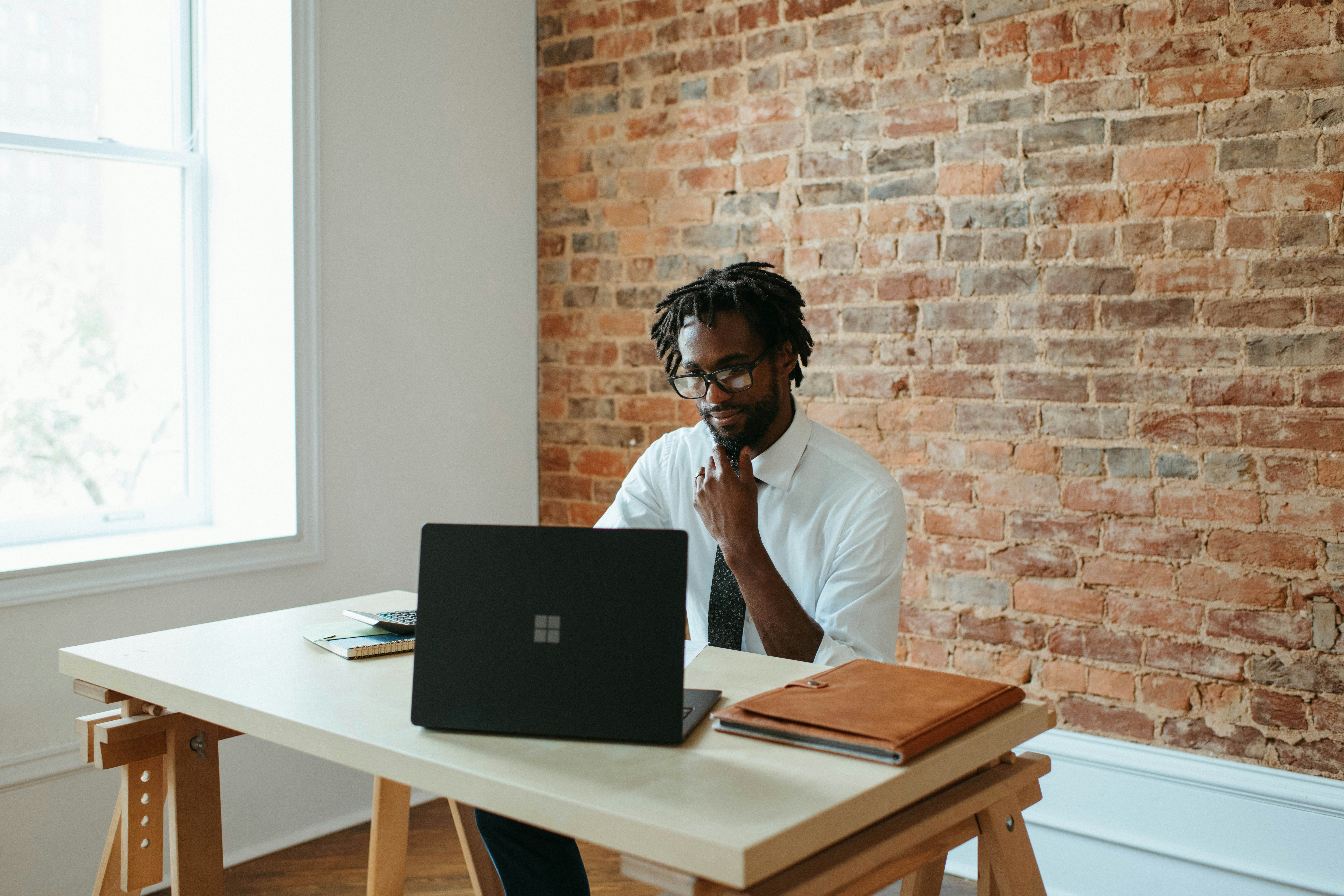 A person sitting at a desk viewing a laptop in an office