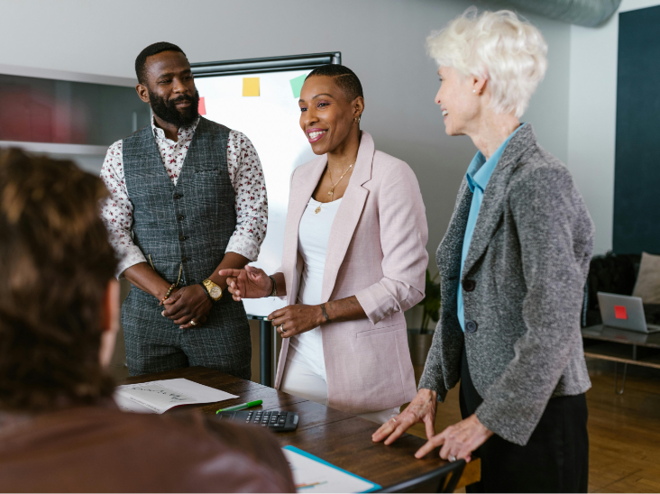 A group of smiling business leaders doing a presentation together