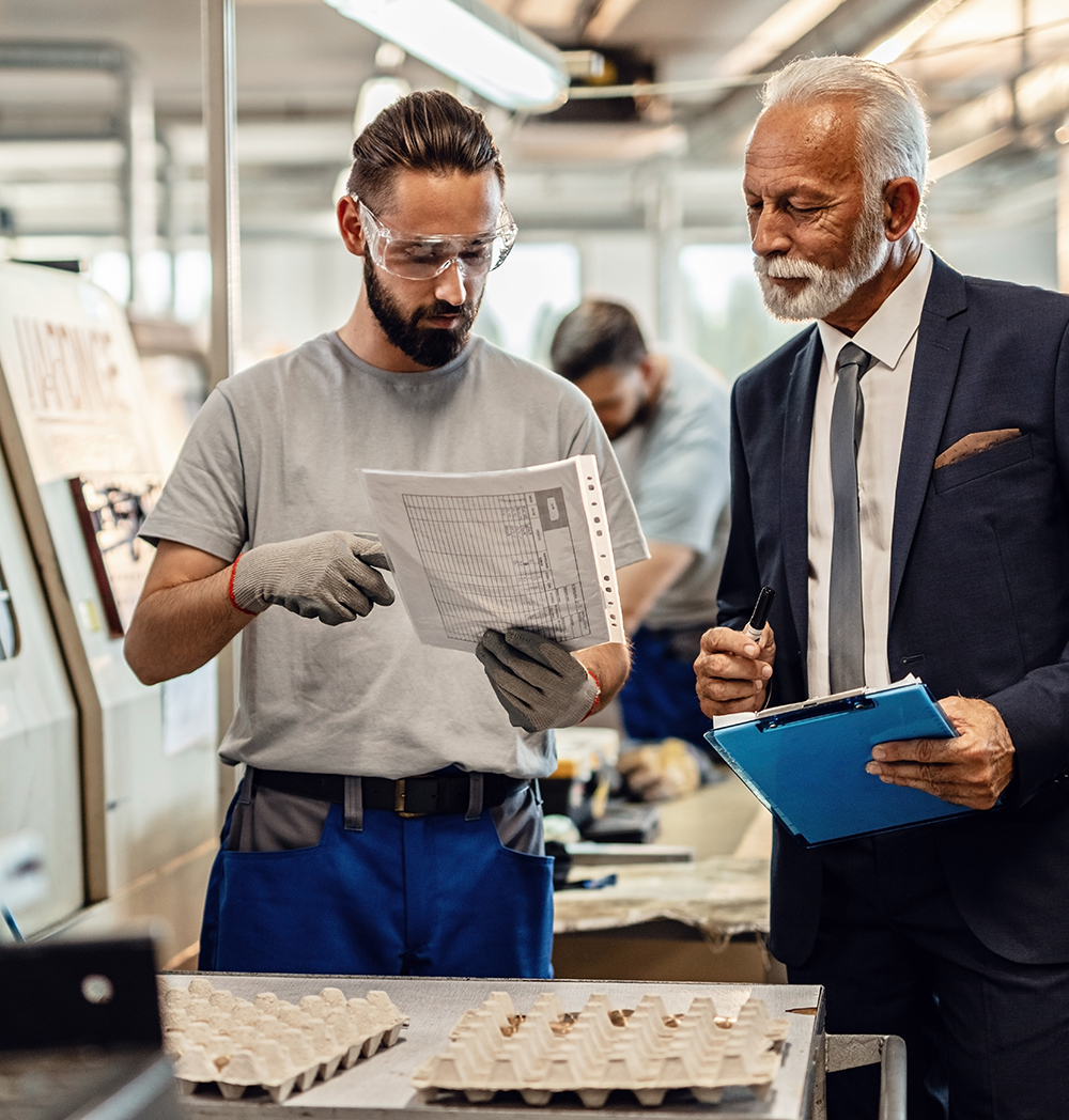 A business leader reviewing a document with an employee